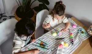girls painting eggs on the table